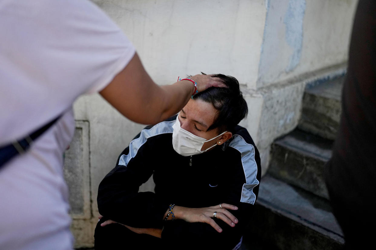 A man sits while waiting to be attended at a hospital. (Natacha Pisarenko / AP)