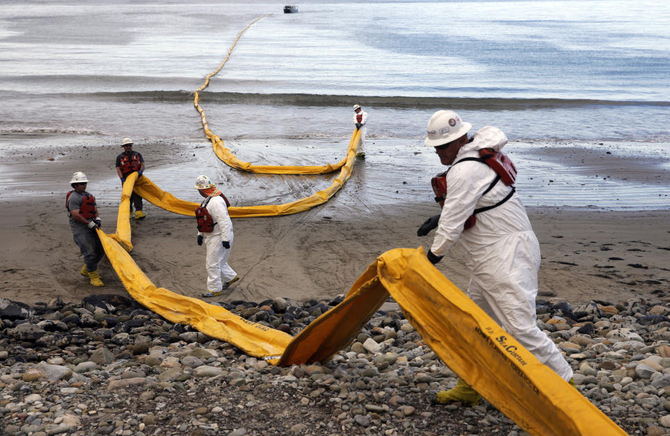 FILE - In this May 21, 2015, file photo, workers prepare an oil containment boom at Refugio State Beach, north of Goleta, Calif., two days after an oil pipeline ruptured, polluting beaches and killing hundreds of birds and marine mammals. California Gov. Gavin Newsom on Saturday, Oct. 12, 2019, signed a law intended to counter Trump administration plans to increase oil and gas production on protected public land. (AP Photo/Jae C. Hong, File)