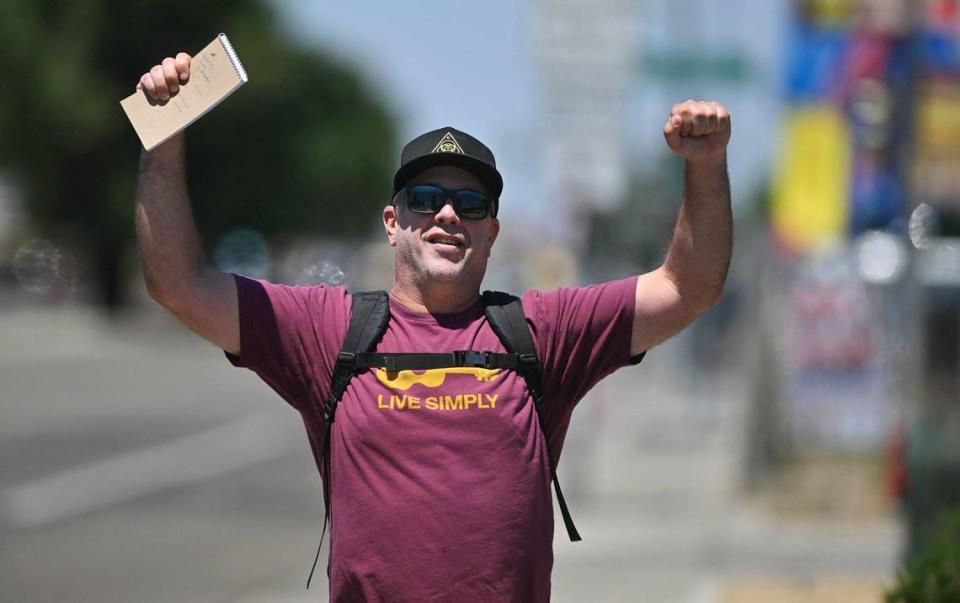 Fresno Bee columnist Marek Warszawski celebrates his hike along Blackstone Avenue Wednesday, May 8, 2024 in Fresno.