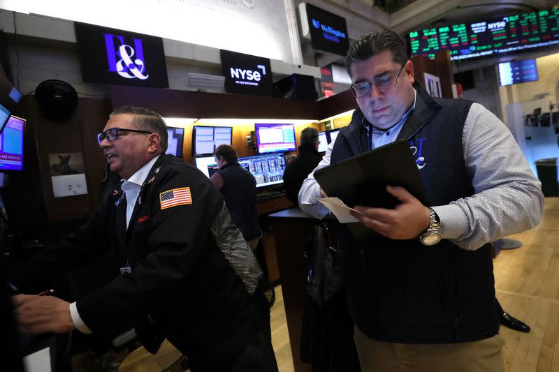 FILE PHOTO: Traders work on the floor of the NYSE in New York