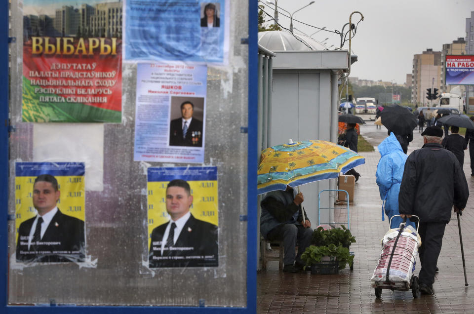 FILE - A vendor sells vegetables next to official leaflets with competing parliamentary candidates' information displayed, and election posters of contenders in Minsk, Belarus, on Sept. 20, 2012. Belarusians will cast ballots Sunday in tightly controlled parliamentary and local elections that are set to cement an authoritarian leader's rule, despite calls for a boycott by an opposition leader who described the balloting as a "senseless farce." (AP Photo, File)