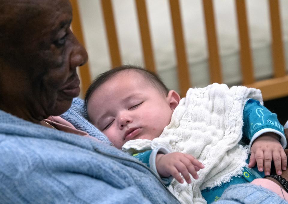 Margaret Ferguson holds a sleeping infant at the Cedar Street Day Nursery of Abilene on March 9.