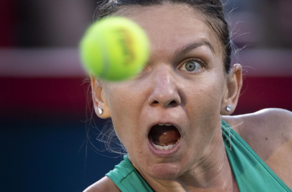 Simona Halep, of Romania, watches the ball as she returns to Caroline Garcia, of France, during women's quarterfinal play at the Rogers Cup tennis tournament in Montreal on Friday, Aug. 10, 2018. (Paul Chiasson/The Canadian Press via AP)