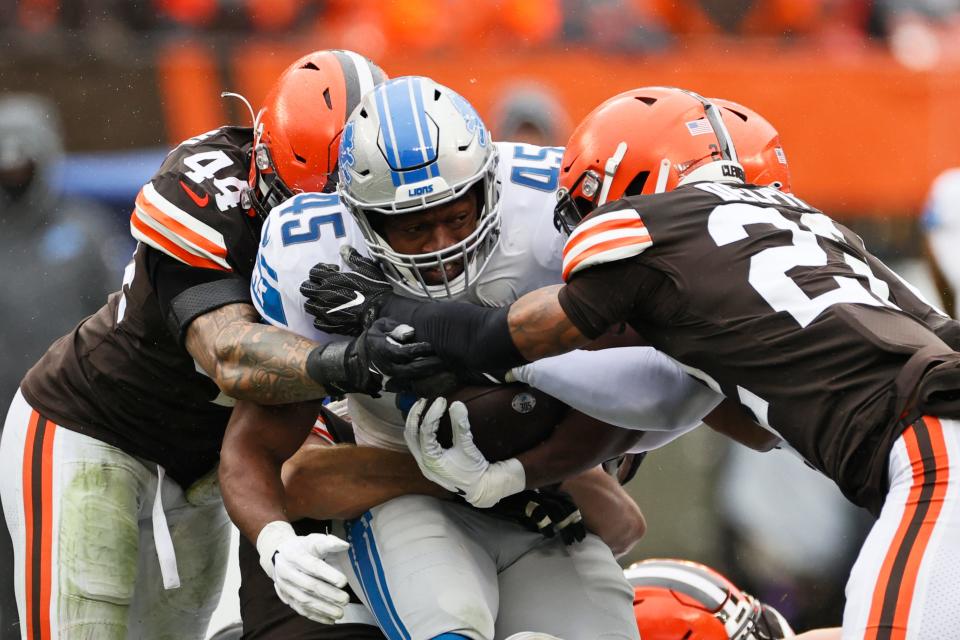 Detroit Lions fullback Jason Cabinda (45) runs with the ball against Cleveland Browns linebacker Sione Takitaki (44) and safety Grant Delpit (22) during the first half of an NFL football game against the Cleveland Browns, Sunday, Nov. 21, 2021, in Cleveland.