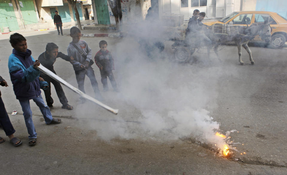 FILE - In this Jan. 19, 2009 file photo, children play with a flaming lump, allegedly containing white phosphorus, on a street in the town of Beit Lahiya, in the northern Gaza strip. A new report by Human Rights Watch and Harvard's human rights clinic released on Monday, Nov. 9, 2020, has documented the use of incendiary weapons and their horrific human cost on civilians over the past decade in conflict zones like Afghanistan, the Gaza Strip and Syria. (AP Photo/Ben Curtis, File)