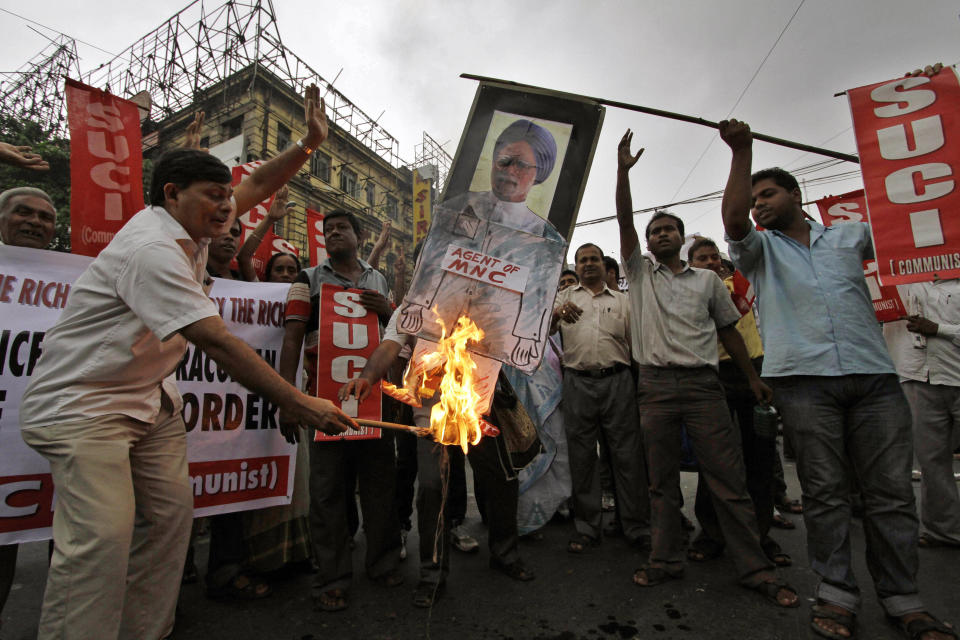 Activists of Socialist Unity Center of India (SUCI) burn an effigy with a portrait of Indian Prime Minister Manmohan Singh during a protest in Kolkata, India, Saturday, Sept. 15, 2012. The protest was against the government’s decision to let in foreign retailers, rise in the price of diesel fuel and also reduction in cooking gas subsidies. (AP Photo/Bikas Das)