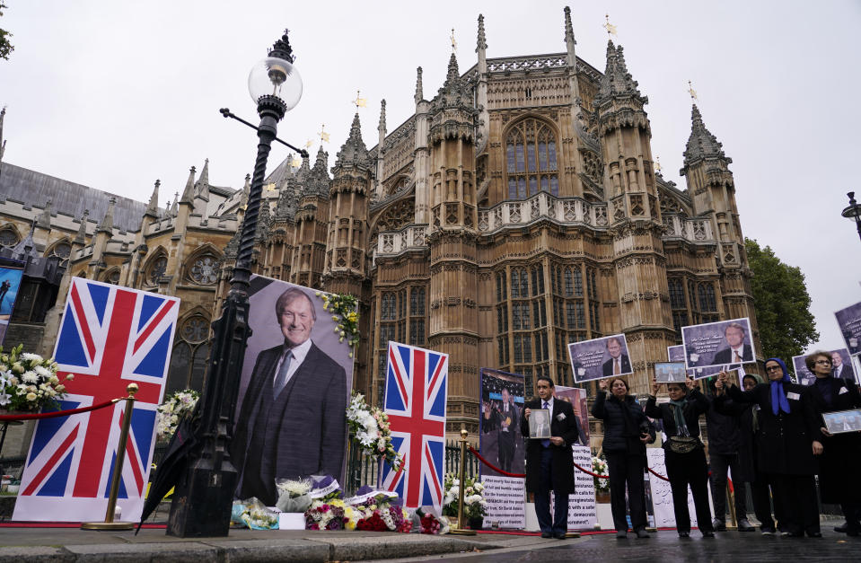 Members of the Anglo-Iranian communities and supporters of the National Council of Resistance of Iran hold a memorial service for British MP David Amess outside the Houses of Parliament in London, Monday, Oct. 18, 2021. British lawmaker David Amess was killed on Friday during a meeting with constituents at the Belfairs Methodist church, in Leigh-on-Sea, Essex, England. (AP Photo/Alberto Pezzali)