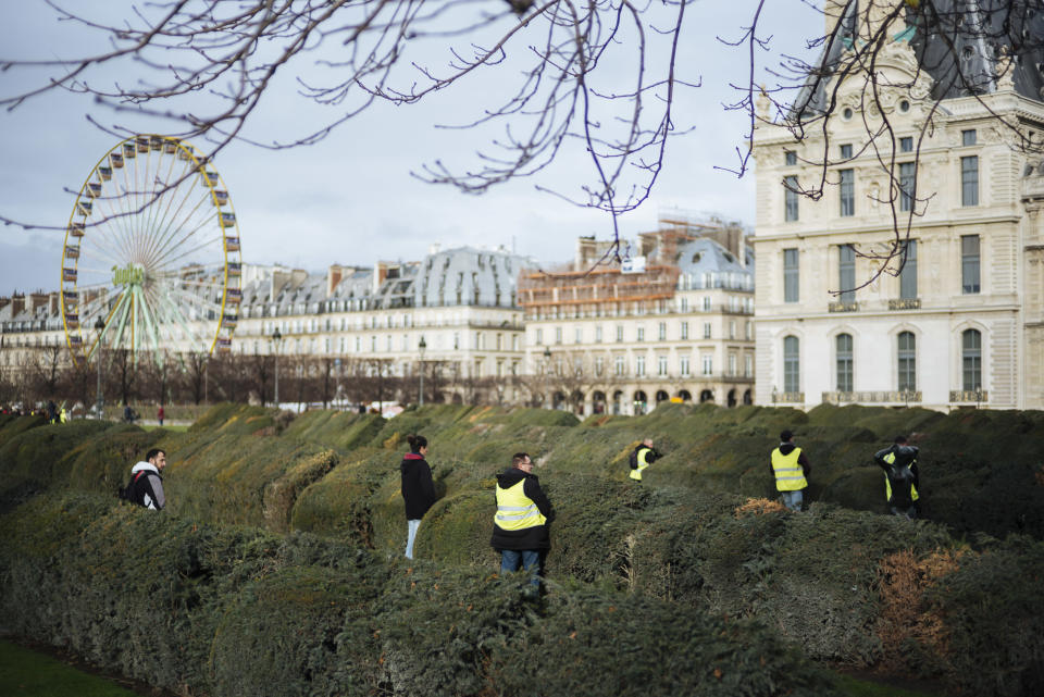 Demonstrators wearing yellow vests urinate in the Tuileries gardens during a demonstration in Paris Saturday, Dec. 22, 2018. A few hundred protesters cordoned by the police did walk across Paris toward the Madeleine Church near the Elysee Palace but were stopped by police in a small adjacent street as some shop owners closed down early. Tempers frayed and police fired tear gas to repel protesters trying to break through the police line. (AP Photo/Kamil Zihnioglu)