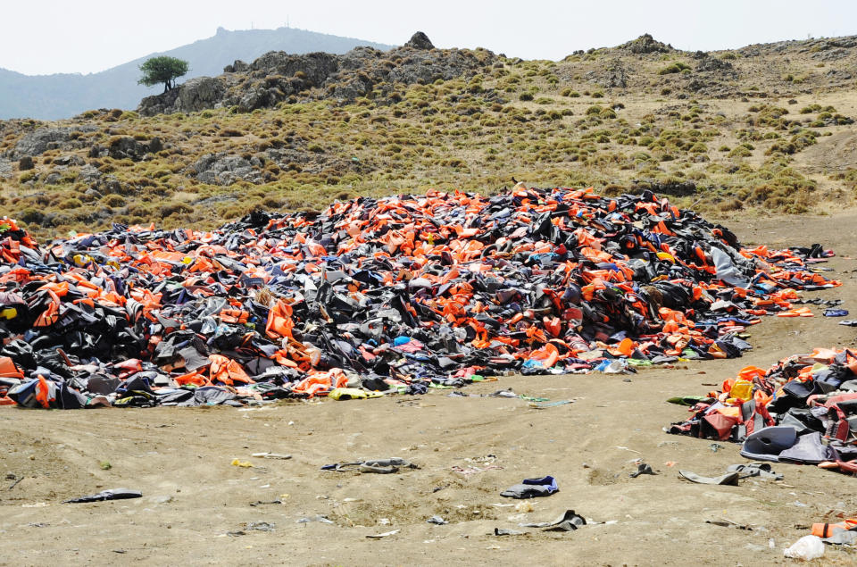 Lifejackets from past journeys to Greece are piled several feet high in a landfill atop Lesbos island.