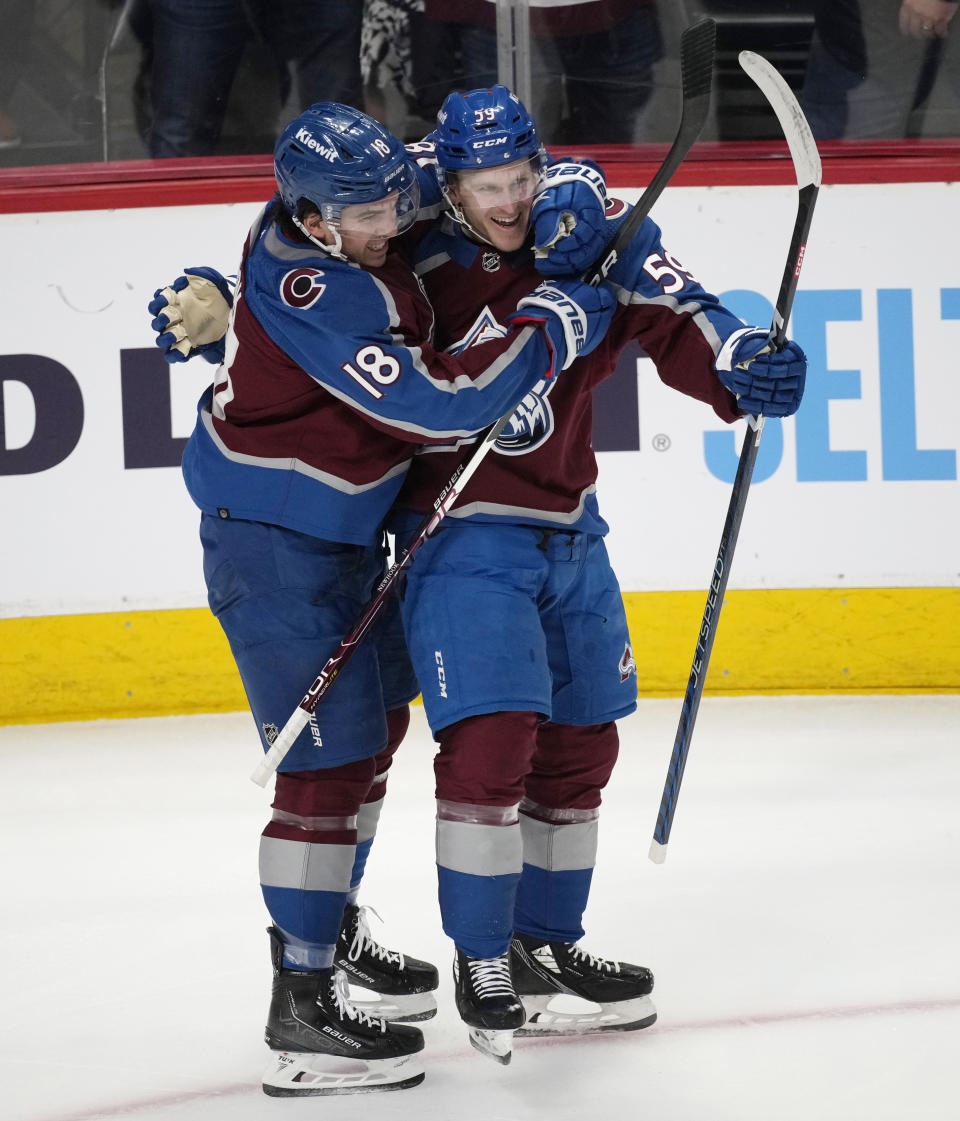 Colorado Avalanche center Alex Newhook, left, hugs center Ben Meyers, who scored a goal against the Edmonton Oilers during the first period of an NHL hockey game Tuesday, April 11, 2023, in Denver. (AP Photo/David Zalubowski