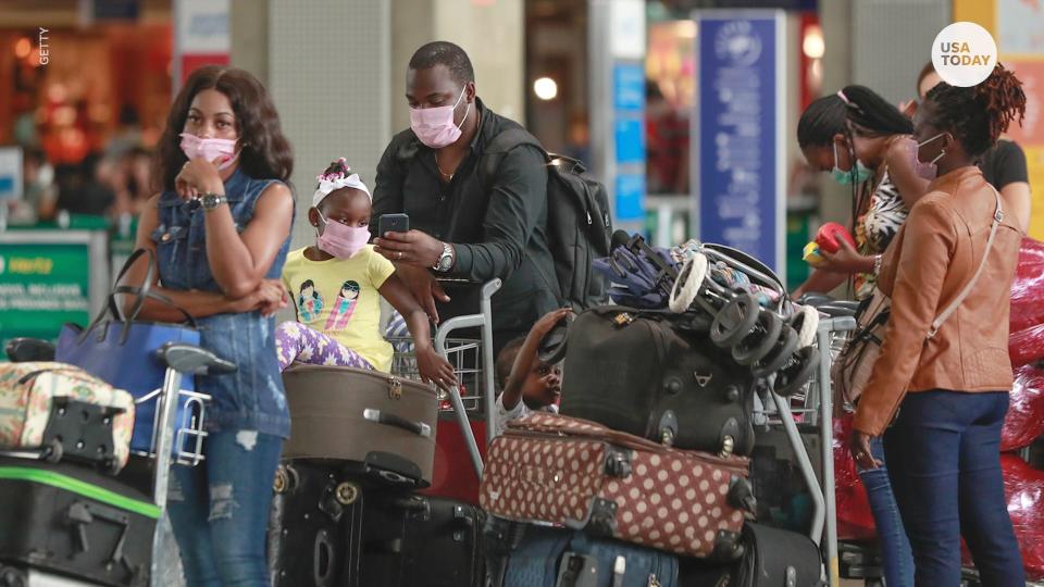 People wear masks at an airport.