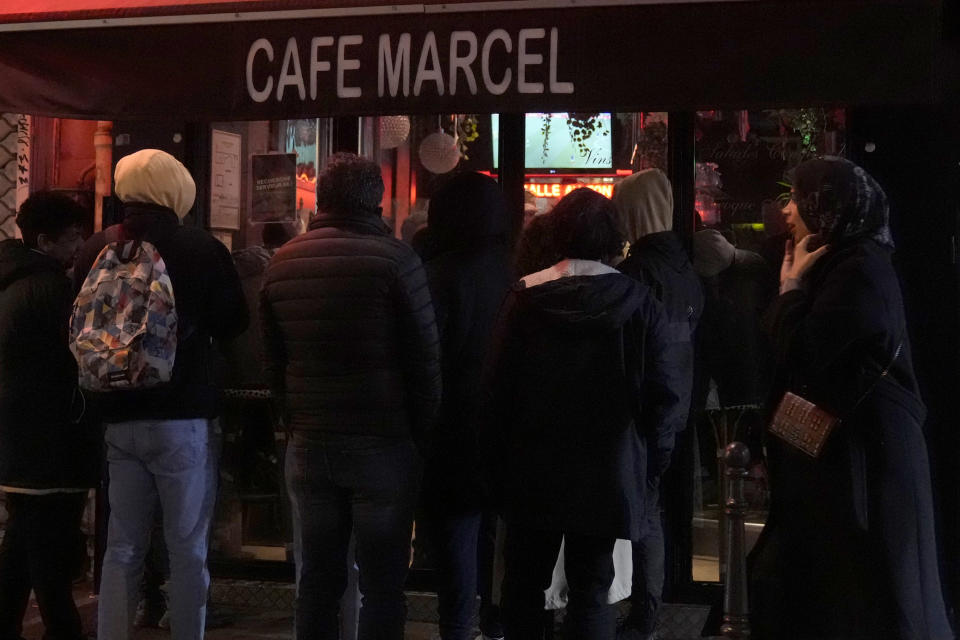 FILE - Supporters of France look from outside during the World Cup quarterfinal soccer match between France and England, being shown live on television in a bar, in Paris, Saturday, Dec. 10, 2022. Every meeting of Morocco and France, the North African country's former colonial ruler, meet in an international tournament, emotions run high among players and their supporters. Family tales of colonial past emerge among the Moroccans and stories of harsh life of immigrants in France bubble up with questions of national loyalty pop up to French players with immigrant roots. (AP Photo/Francois Mori, File)