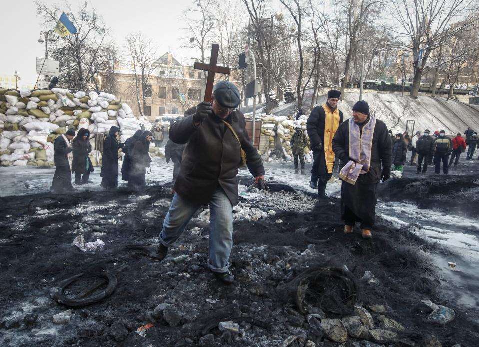 Members of the clergy walk at the site of clashes between anti-government protesters and police in Kiev