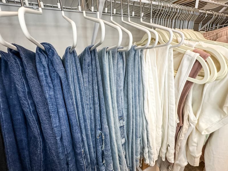 Clothing organized on hangers in a closet.