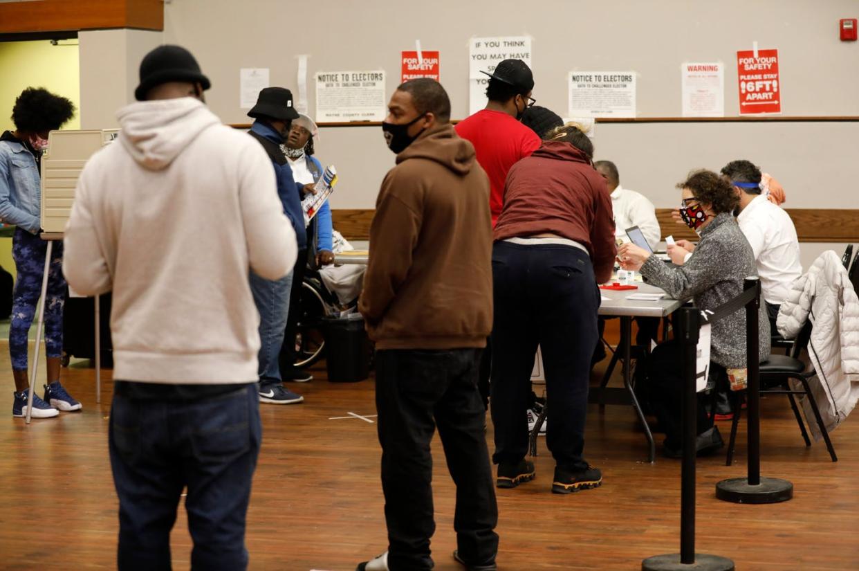 <span class="caption">People wait in line to get their ballot to vote in the 2020 general election in Detroit, Michigan. </span> <span class="attribution"><a class="link " href="https://www.gettyimages.com/detail/news-photo/people-wait-in-line-to-get-their-ballot-to-vote-in-the-2020-news-photo/1229448175?adppopup=true" rel="nofollow noopener" target="_blank" data-ylk="slk:Photo by JEFF KOWALSKY/AFP via Getty Images;elm:context_link;itc:0;sec:content-canvas">Photo by JEFF KOWALSKY/AFP via Getty Images</a></span>