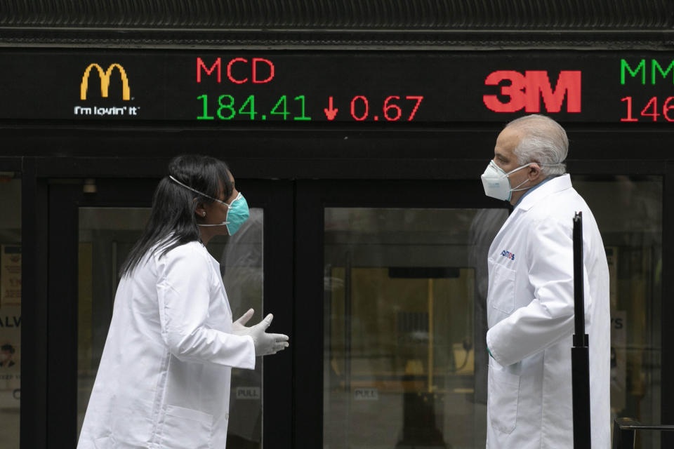 IMAGE DISTRIBUTED FOR THE NEW YORK STOCK EXCHANGE - Health care screeners talk outside the New York Stock Exchange, as the trading floor partially reopens on Tuesday, May 26, 2020, in New York. The floor, known worldwide for an anarchic atmosphere with traders shouting orders over one another, has been closed since mid-March due to the coronavirus outbreak. The NYSE says fewer traders will be on the floor at a given time for now in order to support six-feet social distancing requirements. They also must wear masks. (Mark Lennihan/AP Images for THE NEW YORK STOCK EXCHANGE )