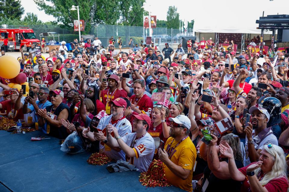 Washington Commanders fans participate in a pep rally to celebrate the purchase of the team.