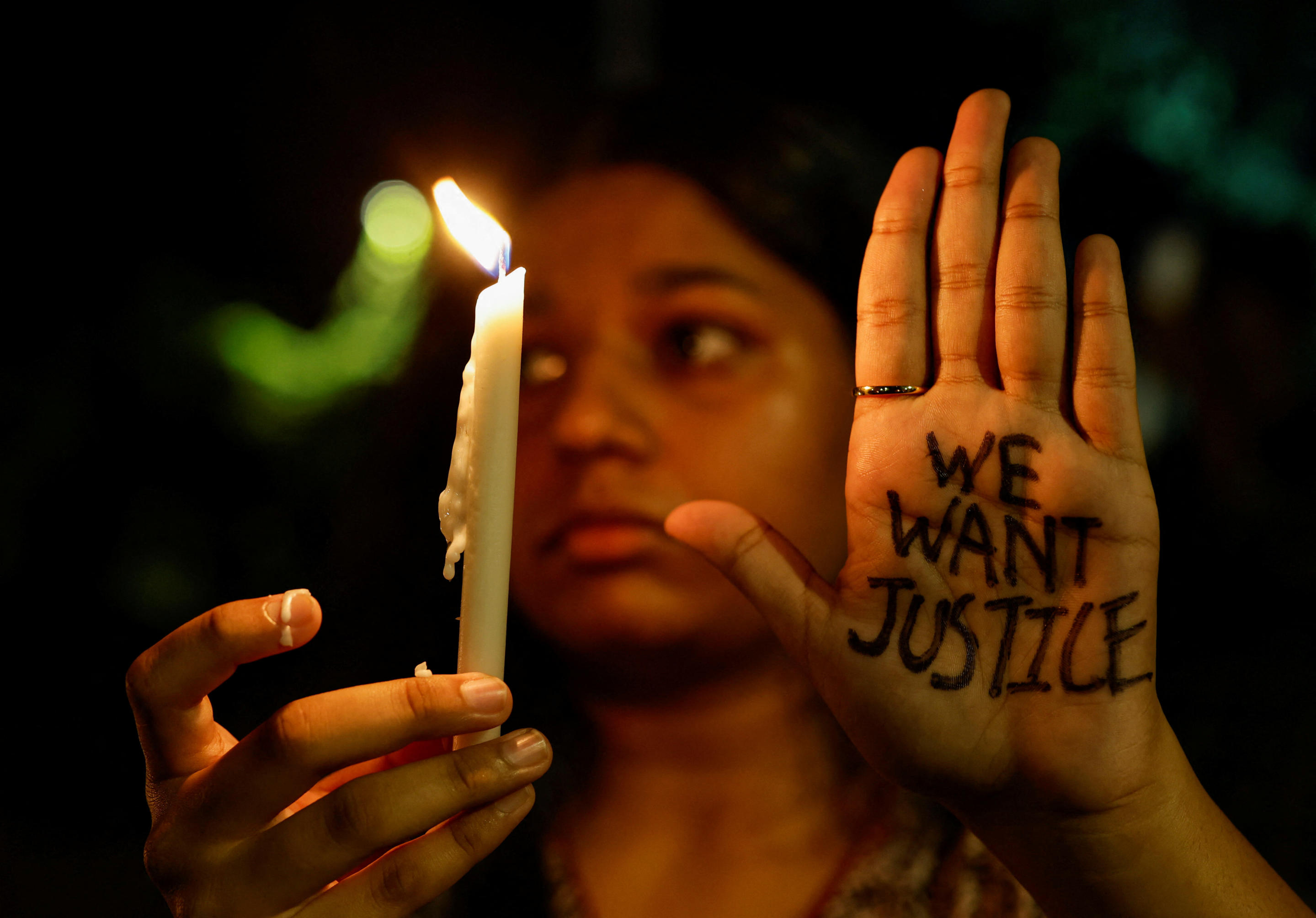 A woman holds a candle during a vigil in Mumbai, India, on Wednesday, condemning the rape and killing of a trainee doctor at a government-run hospital.