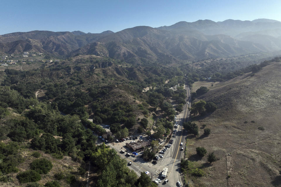 This aerial photo shows Cook's Corner, bottom center, Thursday, Aug. 24, 2023, in Trabuco Canyon, Calif. Gunfire at a popular Southern California biker bar killed three people and wounded five others, and the gunman — believed to be a retired law enforcement officer — was fatally shot by deputies, authorities said. (AP Photo/Jae C. Hong)