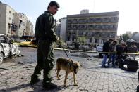 Syrian policemen and security forces gather at the site of a suicide attack at a police officer's club in the Masaken Barzeh district of the capital Damascus on February 9, 2016