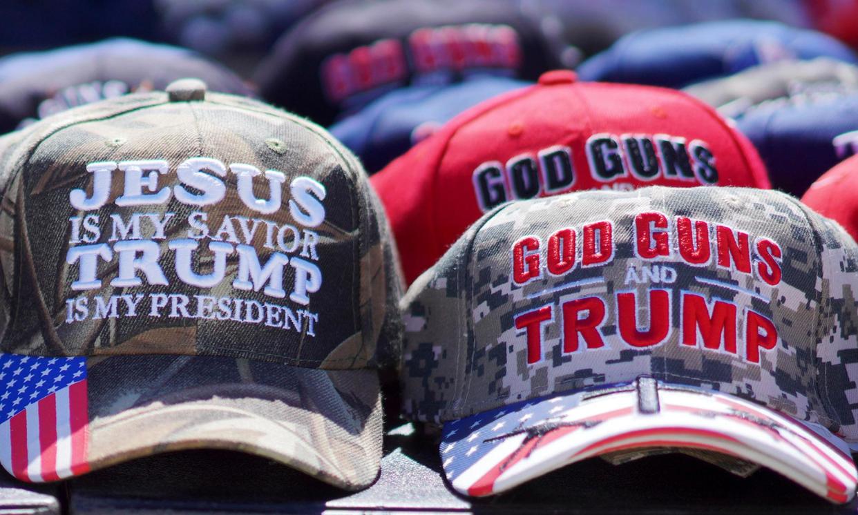 <span>Hats with the slogans ‘God, Guns and Trump’ and ‘Jesus is my savior, Trump is my president’ are sold at a campaign rally.</span><span>Photograph: Jessie Wardarski/AP</span>