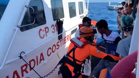 Still image taken from a video shows minors who were among migrants stranded on the Spanish migrant rescue ship Open Arms as they disembark in Lampedusa