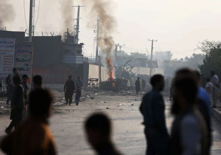 Angry Afghan protesters burn tires and shout slogans at the site of a blast in Kabul