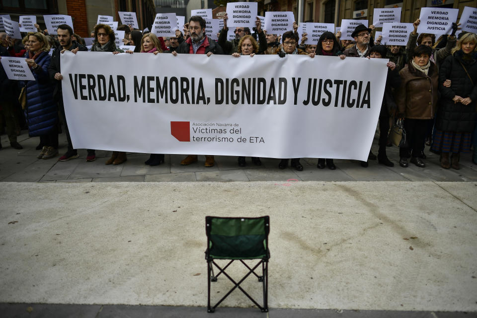 FILE - In this Dec. 28, 2018 file photo, relatives of people killed by the dissolved Basque armed group ETA, hold banners that read: "True, Memory, Dignity, Justice", in tribute to the victims, in Pamplona, northern Spain. Josu Urrutikoetxea, the last known chief of ETA, the now-extinct Basque separatist militant group, goes on trial Monday Oct. 19, 2020 in Paris for terrorism charges that he deems “absurd” because of his role in ending a conflict that claimed hundreds of lives and terrorized Spain for half a century. (AP Photo/Alvaro Barrientos, File)