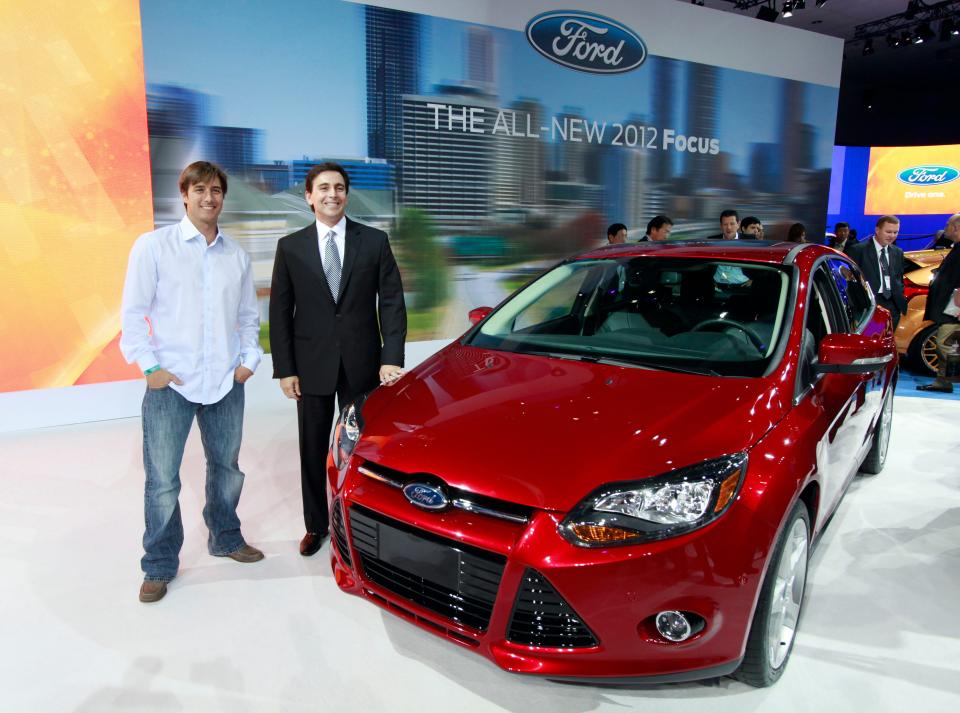 Mark Fields, Ford president for the Americas, right, and Olympic skier Johnny Moseley pose with the 2012 model year Ford Focus makes its debut at the LA Auto Show Wednesday, Nov. 17, 2010.  Moseley is scheduled to host a reality-type TV show titled "Focus Reality America," centered around the car, next spring.  (AP Photo/Reed Saxon)