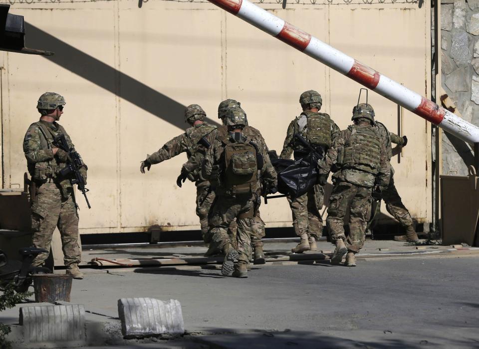 U.S. troops carry the dead body of a soldier from a NATO-led international military force, at the site of a suicide attack in Kabul September 16, 2014. (REUTERS/Omar Sobhani)