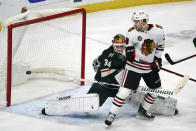 Chicago Blackhawks' Brandon Hagel, right, watches a power-play goal by Alex DeBrincat get by Minnesota Wild goalie Kaapo Kahkonen during the first period of an NHL hockey game Saturday, Jan. 22, 2022, in St. Paul, Minn. (AP Photo/Jim Mone)