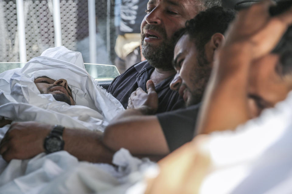 Muhammad al-Habil, killed along with his uncle Abdul Muti al-Habil, is cradled by his father on the way to the funeral of the two men, in Deir al Balah, Gaza Strip, Friday June 14, 2024. The two men were killed while fishing in the sea when Israeli gunboats opened fire on them. (AP Photo/Mohammad Hajjar)