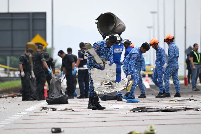 <p>MOHD RASFAN/AFP via Getty Images</p> Members of the Special Disaster and Emergency Response team collect debris at the crash site in Shah Alam on August 18, 2023 a day after a light plane crashed in Malaysia's central Selangor state.