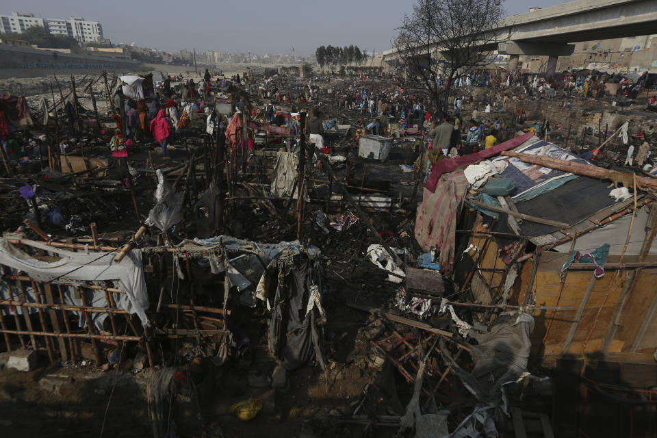 CAPTION CORRECTION: CORRECTS YEAR: Dwellers collect their belongings following a fire that gutted homes in Karachi, Pakistan, Wednesday, Jan. 22, 2020. Hundreds of huts were burnt to ashes as fire erupted making dozens of families homeless in a slum of Karachi, local media reported. (AP Photo/Fareed Khan)