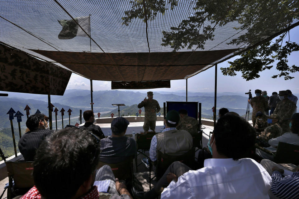 A senior army officer briefs journalists at a hilltop post in Chiri Kot sector near the Line of Control, that divides Kashmir between Pakistan and India, Wednesday, July 22, 2020. Villagers living along a highly militarized frontier in the disputed region of Kashmir have accused India of "intentionally targeting" civilians, but they are vowing that they would never leave their areas. Villagers say the fear of death is no longer present in their hearts after spending so many years in a state of shock and uncertainty. (AP Photo/Anjum Naveed)