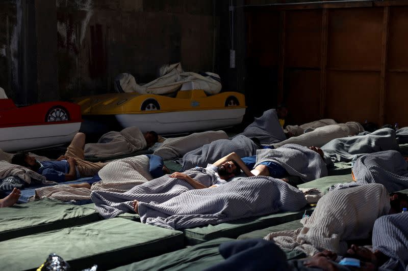 FILE PHOTO: Migrants rest in a shelter, following a rescue operation, after their boat capsized on the open sea, in Kalamata