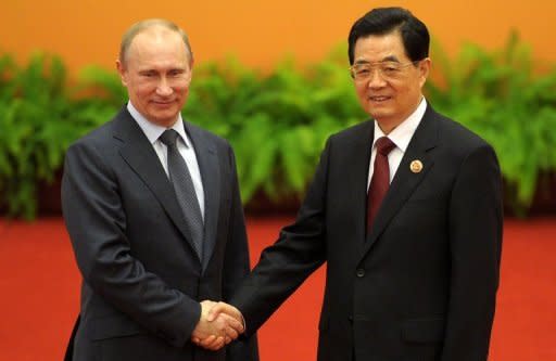 Russia's President Vladimir Putin and Chinese President Hu Jintao, pictured at a summit of the Shanghai Cooperation Organization (SCO) in Beijing. A regional group led by Russia and China said it opposed military intervention in the Middle East, a day after the Syrian opposition accused forces loyal to the regime of massacring 100 people