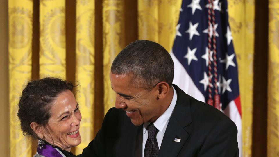 julia alvarez smiling as she hugs president barack obama