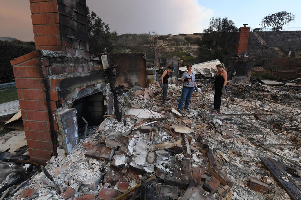 <p>Members of the Reinhardt family sort through the remains of their family home in Ventura, California, on December 6.</p>