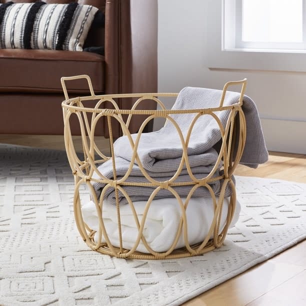 the rattan basket with blankets inside on a carpet