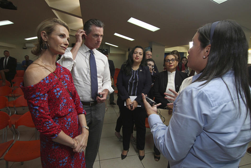 California Gov. Gavin Newsom with his wife, Jennifer Siebel Newsom, left, are welcomed by Ana Solorzano, head of the Department for Migrant Care, DGME, right, as they visit La Chacra Immigration Center in San Salvador, El Salvador, Monday, April 8, 2019. Third from left is California State Assemblywoman Wendy Carrillo. (AP Photo/Salvador Melendez)