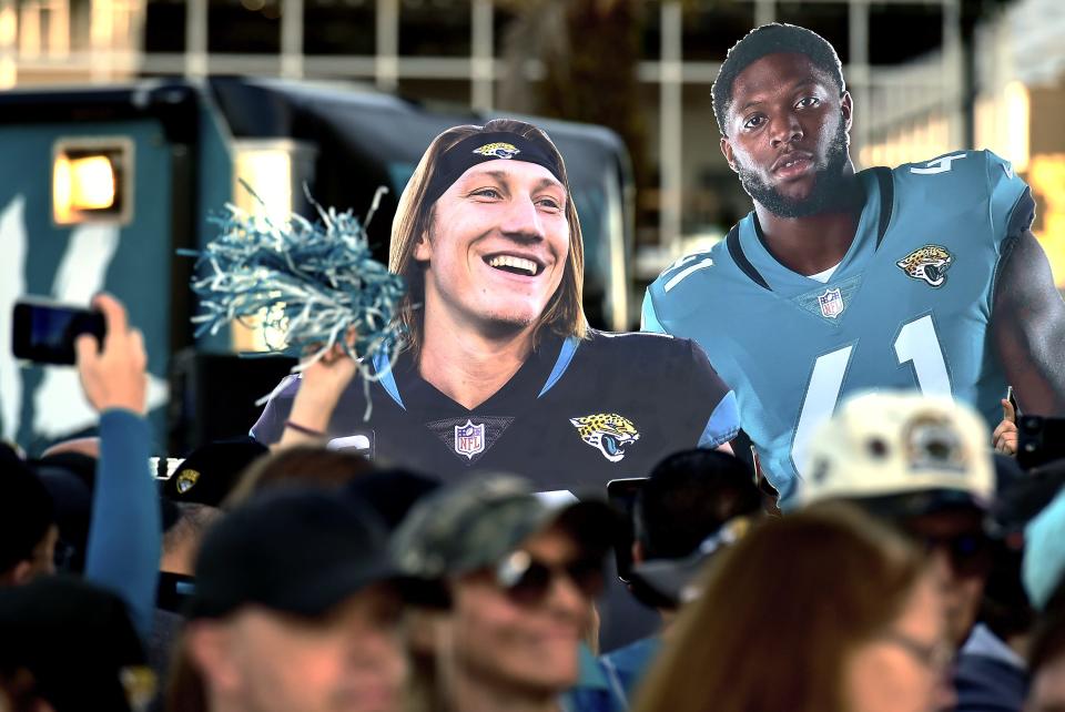 Oversized photos of Jacksonville Jaguars quarterback Trevor Lawrence (16) and teammate linebacker Josh Allen (41) are carried behind the crowd as they waited for the team to leave the stadium Friday morning. Hundreds of Jacksonville Jaguar fans waited outside the West entrance of TIAA Bank Field Friday morning, January 20, 2023, to cheer on the team as they headed to their cars to drive to the airport for their flight to Kansas City to play their AFC divisional round game against the Chiefs on Saturday.