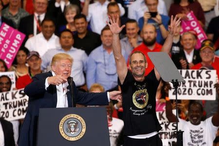 U.S. President Donald Trump invites a supporter onstage with him during a "Make America Great Again" rally at Orlando Melbourne International Airport in Melbourne, Florida, U.S. February 18, 2017. REUTERS/Kevin Lamarque