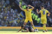 Ukraine's Taras Stepanenko, center top, duels for the ball with Scotland's John McGinn during the World Cup 2022 qualifying play-off soccer match between Scotland and Ukraine at Hampden Park stadium in Glasgow, Scotland, Wednesday, June 1, 2022. (AP Photo/Scott Heppell)