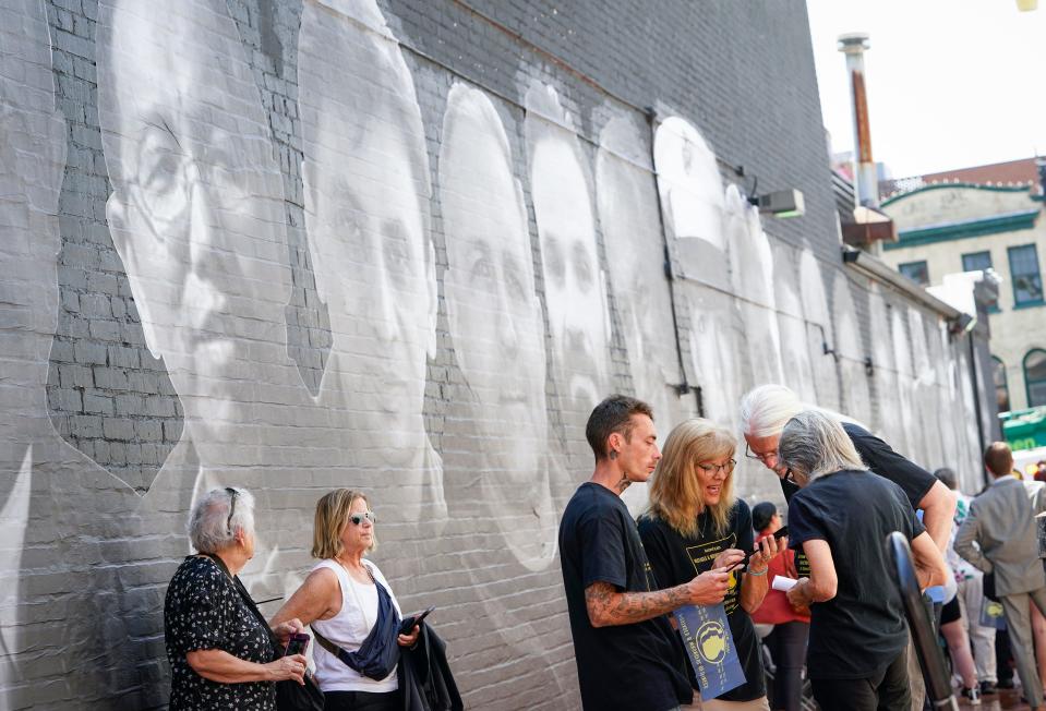 Family members of Matthew Heath, a United States Marine Corps veteran who has been detained in Venezuela since September 9, 2020, move away from the crowd and huddle to listen and talk on an unexpected phone call from Matthew Heath just as a mural honoring 18 wrongfully detained Americans by artist Isaac Campbell is unveiled in Washington DC on Wednesday, July 20, 2022. One of those honored on the mural is Paul Whelan, who has been detained in Russia since 2018. Whelan is a former US Marine and convicted by Russian officials on espionage charges in 2020.