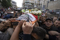 FILE - Palestinian mourners carry the body of veteran Palestinian-American reporter Shireen Abu Akleh out of the office of Al Jazeera after friends and colleagues paid their respects, in the West Bank city of Ramallah, May 11, 2022. Almost two weeks after the death of Abu Akleh, a reconstruction by The Associated Press lends support to assertions from both Palestinian authorities and Abu Akleh's colleagues that the bullet that cut her down came from an Israeli gun. (AP Photo/Nasser Nasser, File)