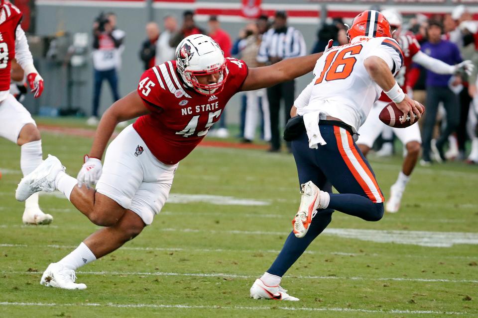 North Carolina State's Davin Vann (45) attempts to tackle Syracuse's Garrett Shrader (16) during the first half of their game in Raleigh Nov. 20, 2021.