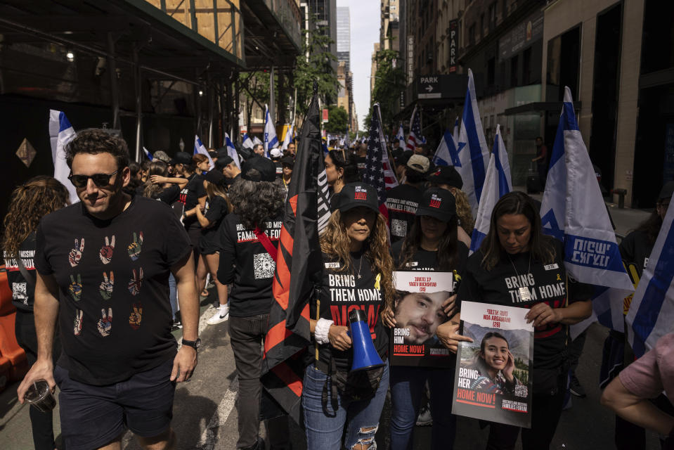 People hold signs and Israeli flags gather ahead of the annual Israel Day Parade on Sunday, June 2, 2024, in New York. (AP Photo/Yuki Iwamura)