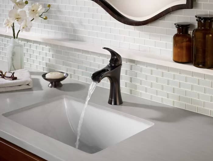 faucet running water while various bathroom sink accessories