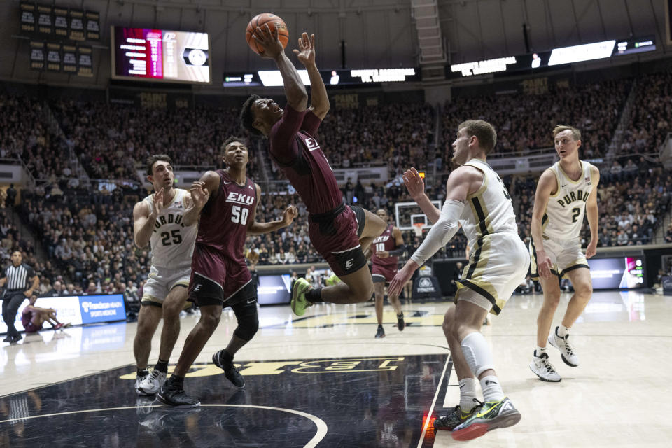 Eastern Kentucky guard Tayshawn Comer dives while shooting the ball in front of Purdue guard Braden Smith during the first half of an NCAA college basketball game Friday, Dec. 29, 2023, in West Lafayette, Ind. (AP Photo/Marc Lebryk)